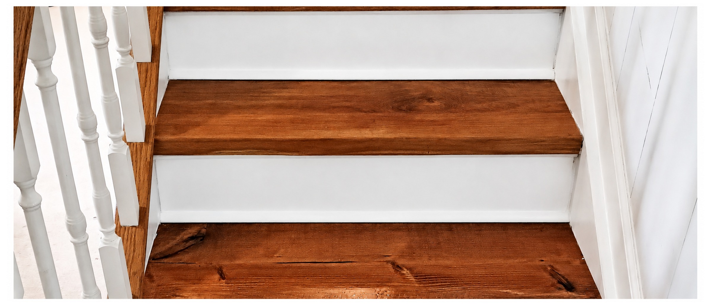 Finished wooden staircase with refinished treads and freshly painted white risers, built by Unique Ends LLC in Montgomery